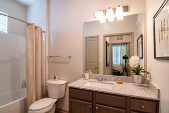 a bathroom with a toilet and a sink and a mirror at Century New Holland, Gainesville, GA, 30501